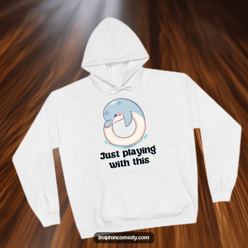 Funny Hoodie: A dolphin joyfully nudges a floating ring, depicted in a funny and heartwarming scene for cozy wear.